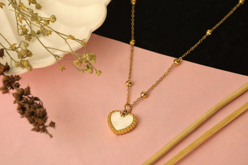 Delicate gold chain necklace with a small heart-shaped pendant.