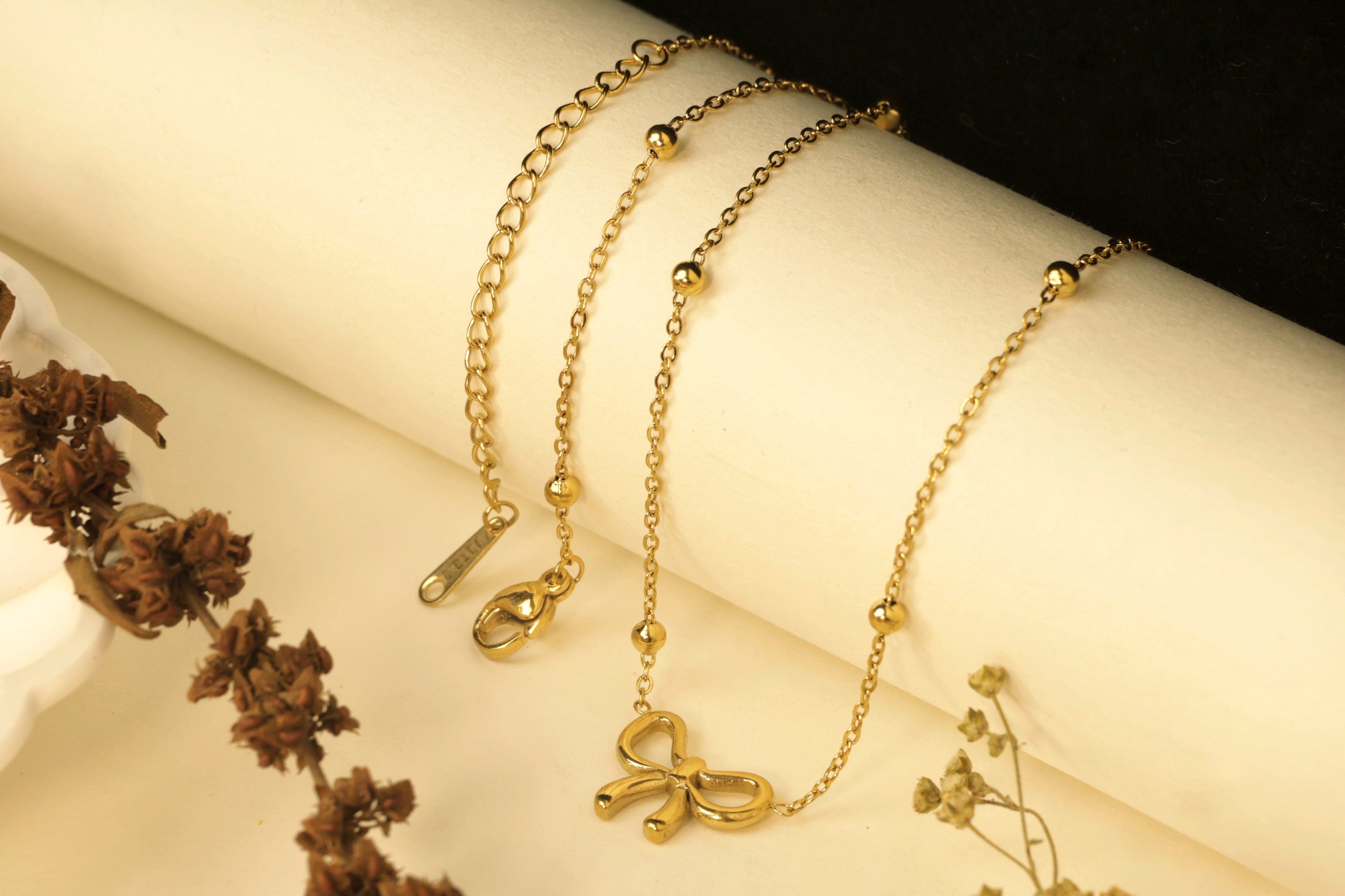 Layered gold necklaces with a knot or tied-loop pendant